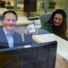 Uomo e donna che sorridono e reggono in mano una tazza con la scritta 'Accueil'.