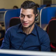 Ragazzo che parla alle cuffie con lo sguardo verso il basso.