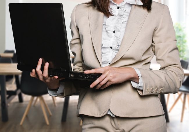 Donna che tiene in mano un computer portatile.