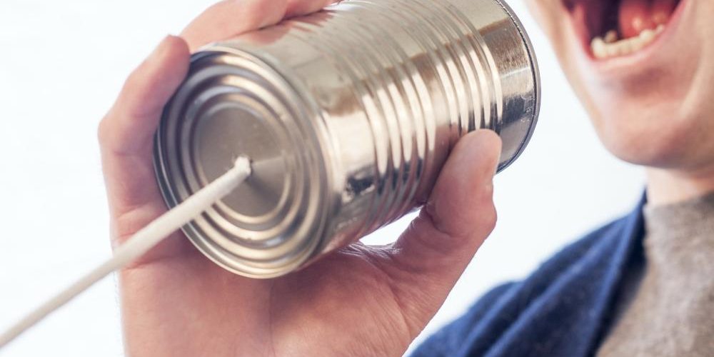 imparare-comunicare-accueil Bocca di uomo che parla dentro una scatola di latta alla quale è collegato un filo