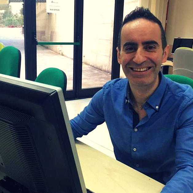 Salvatore-Bruzzese Uomo seduto davanti al computer che sorride