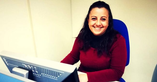 Donna che sorride seduta su una sedia davanti al computer