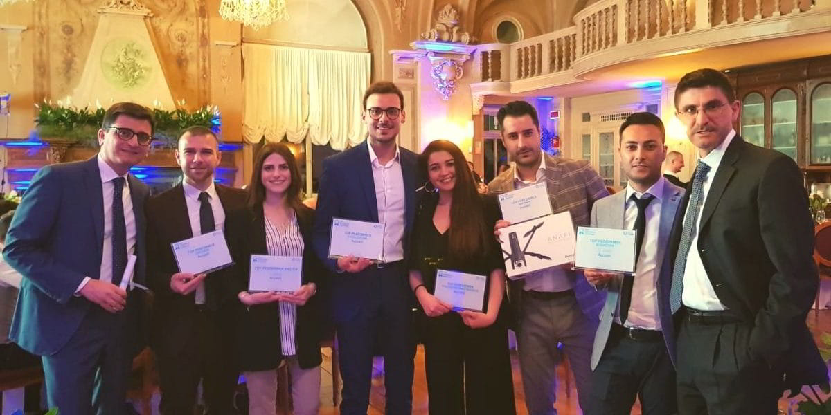 Convetion-A2A-2019-Premiazione Due donne e sei uomini vestiti eleganti che tengono in mano un premio
