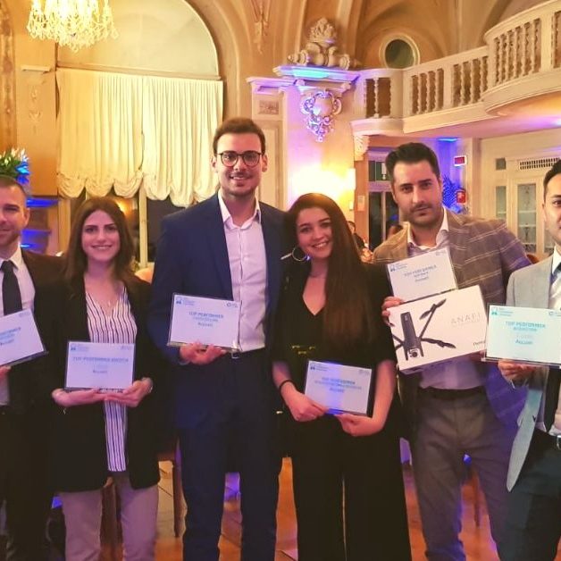 Convetion-A2A-2019-Premiazione Due donne e sei uomini vestiti eleganti che tengono in mano un premio