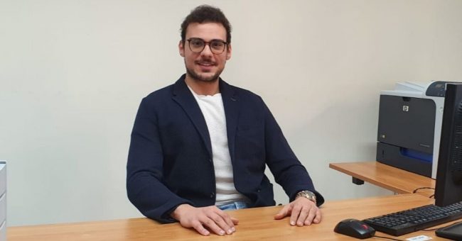Ragazzo con occhiali seduto alla scrivania