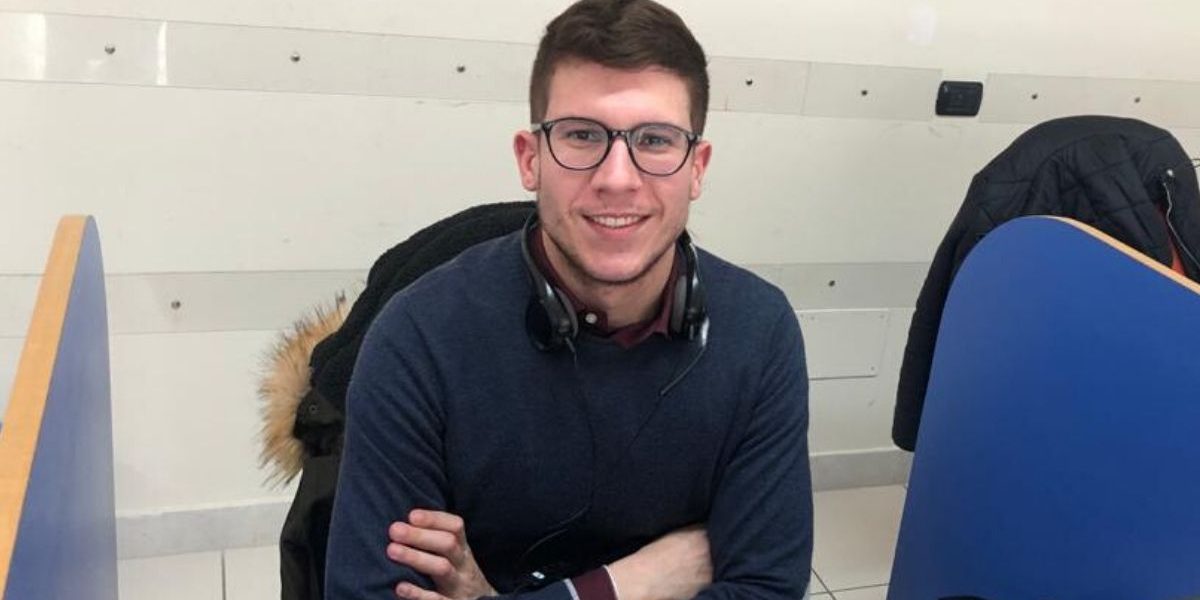 Domenico-Giordano Ragazzo con occhiali seduto alla scrivania con le braccia conserte