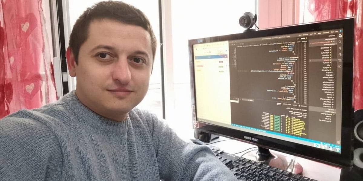 Uomo seduto avente come sfondo lo schermo del computer