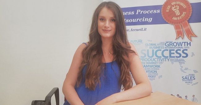 Ragazza seduta ad una scrivania che sorride