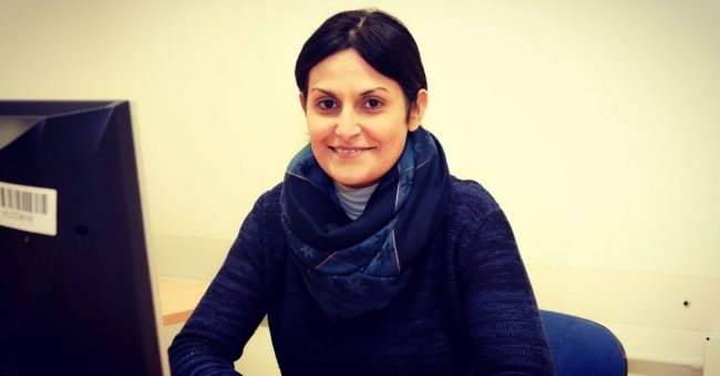 Signora che sorride seduta al computer