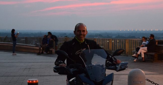 Foto al tramonto con un uomo in motocicletta