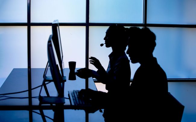 Persone che indossano delle cuffie e lavorano al computer.
