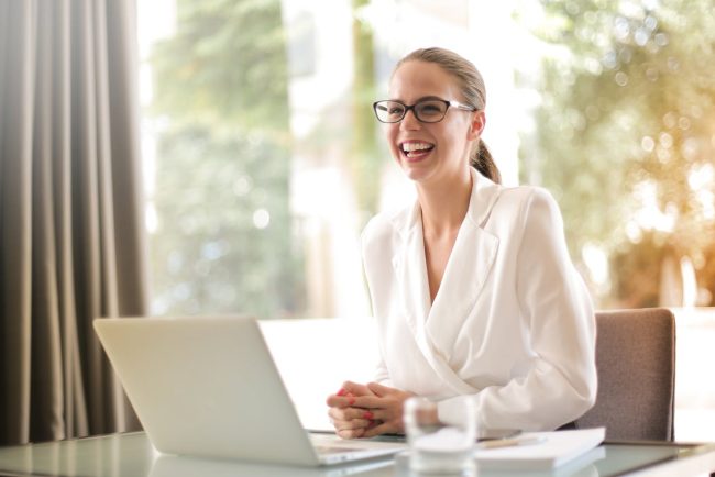 Call center manager seduta davanti a una persona che sorride.